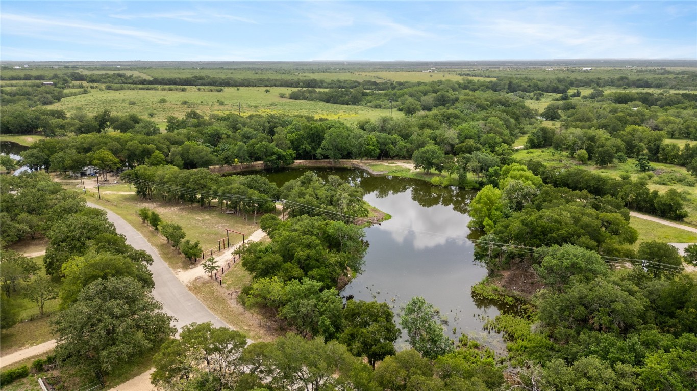 900 Old Lytton Springs Road Lockhart, TX 78644 - Photo 32 of 34 an aerial view of green landscape with trees houses and lake view