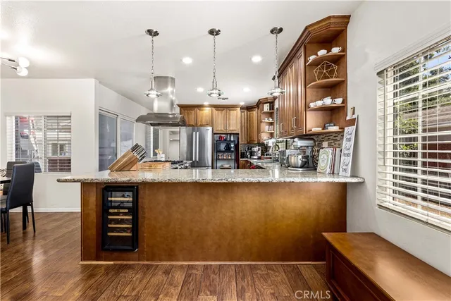 a kitchen with stainless steel appliances granite countertop a sink and wooden floors