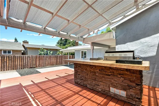 a view of a patio with table and chairs with wooden floor and fence