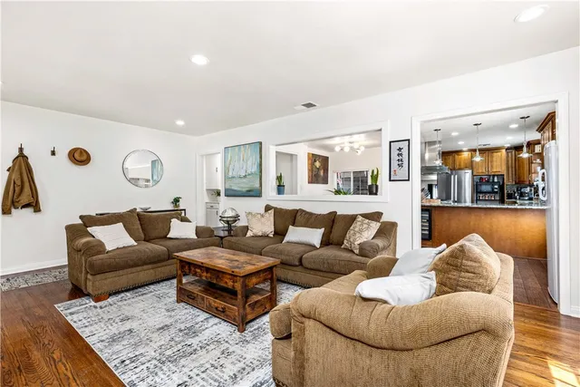 a living room with furniture and view of kitchen