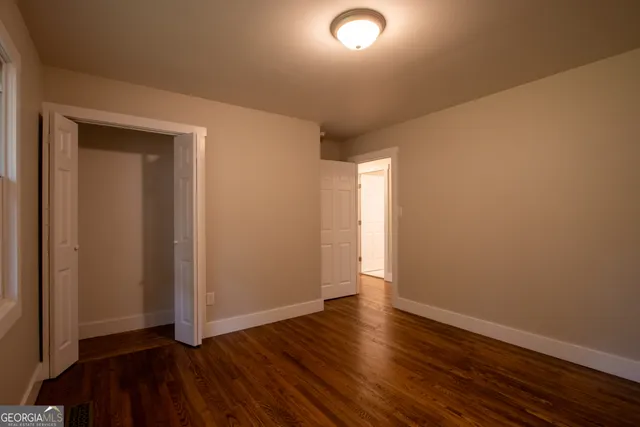 an empty room with wooden floor and closet
