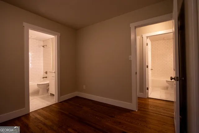 wooden floor in an empty room and a bathroom