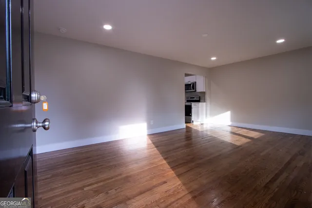 a view of empty room with wooden floor