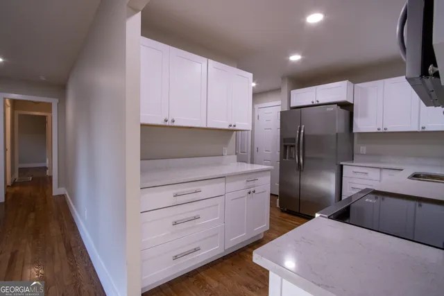 a kitchen with stainless steel appliances a refrigerator a sink a stove top oven a washer and dryer