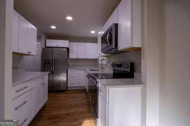 a kitchen with stainless steel appliances a refrigerator sink and microwave