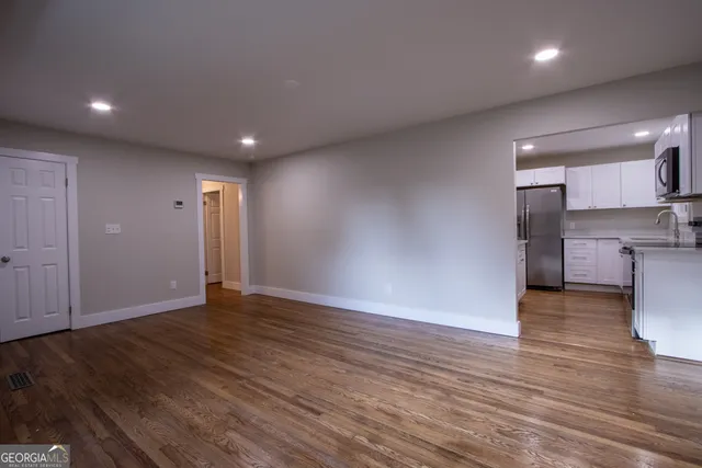 a view of empty room with wooden floor