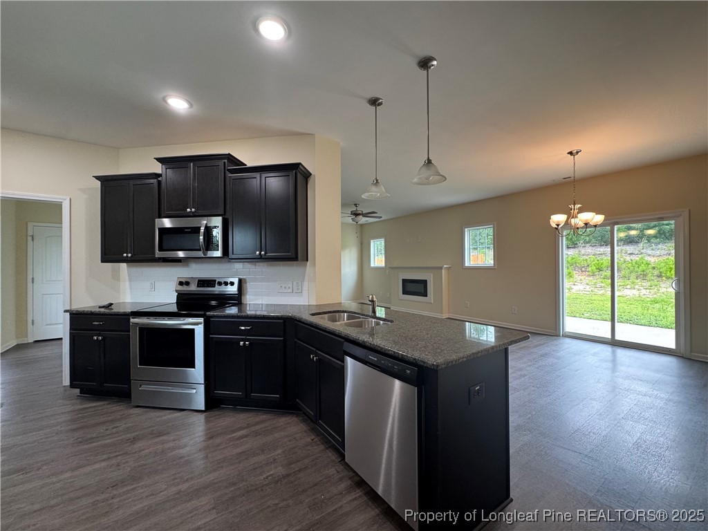 185 Ledgebrook Lane Raeford, NC 28376 - Photo 11 of 32 a kitchen with stainless steel appliances granite countertop wooden cabinets a stove a sink and a wooden floor