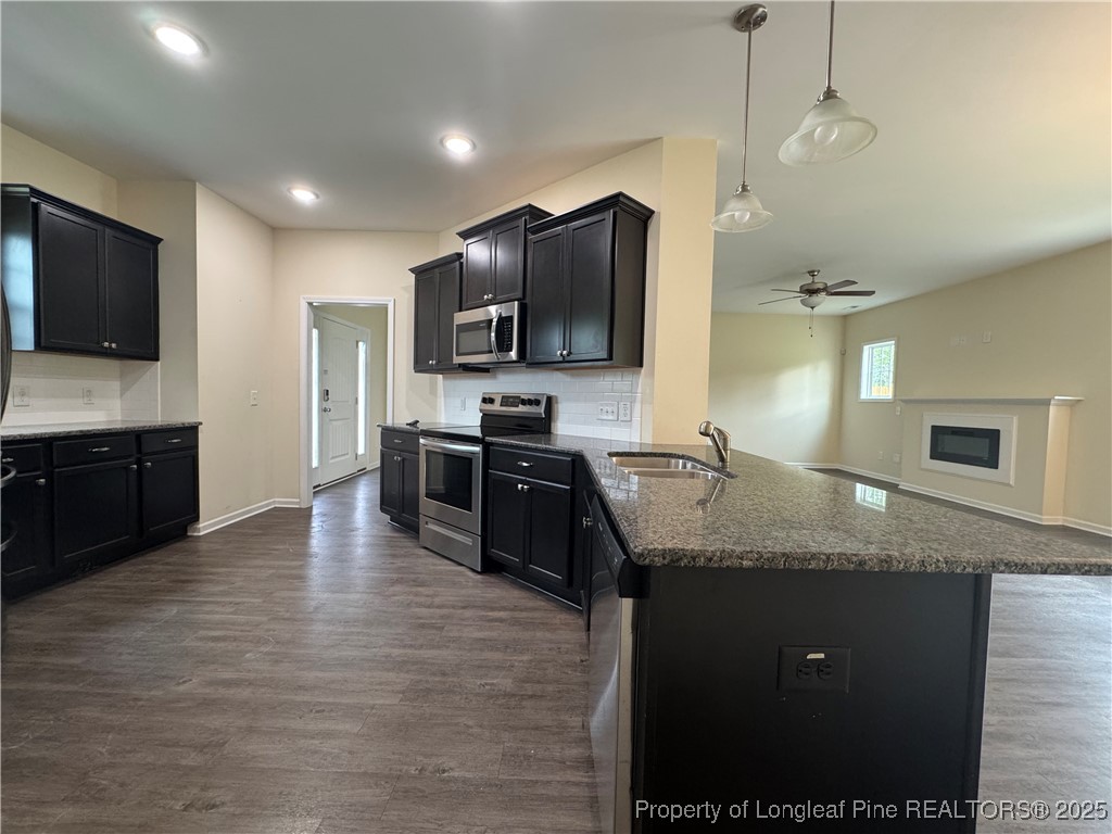 185 Ledgebrook Lane Raeford, NC 28376 - Photo 12 of 32 a large kitchen with granite countertop a sink and a stove top oven with wooden floor