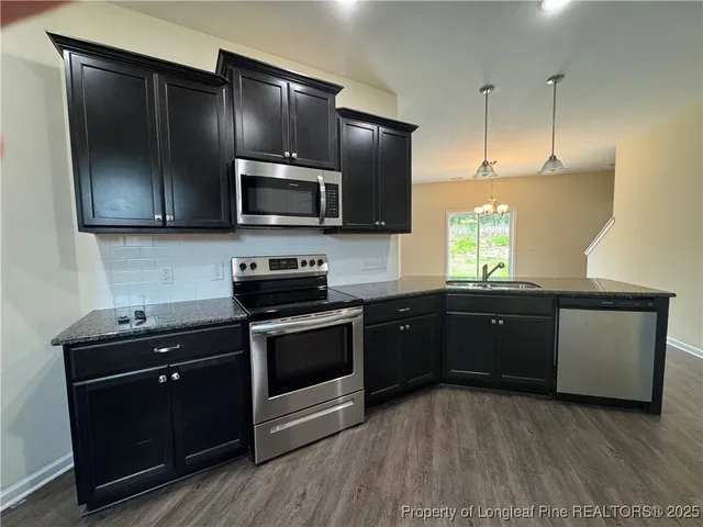 a kitchen with granite countertop a refrigerator and a sink