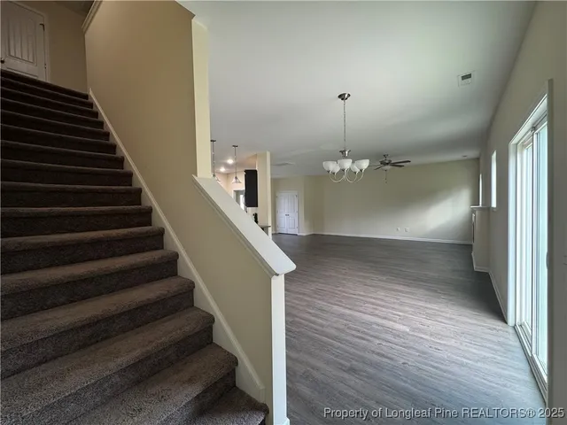 an empty room with windows and refrigerator