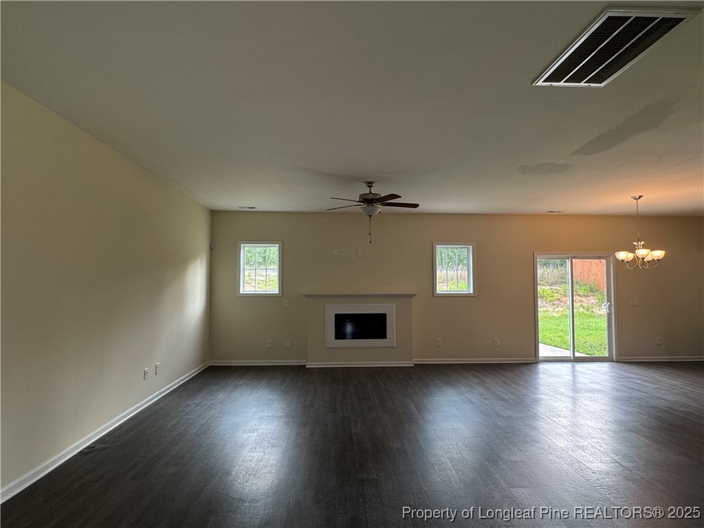 185 Ledgebrook Lane Raeford, NC 28376 - Photo 4 of 32 an empty room with wooden floor fireplace and windows