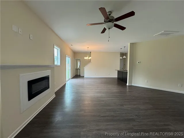 a view of a livingroom with a chandelier wooden floor and a chandelier