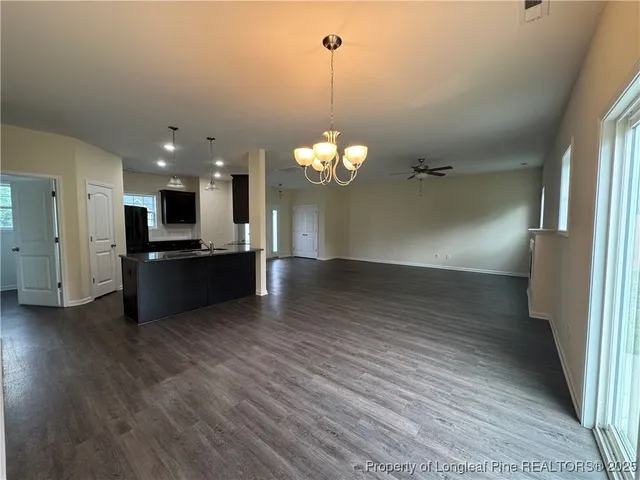 a kitchen with kitchen island granite countertop a sink a counter top space appliances and cabinets
