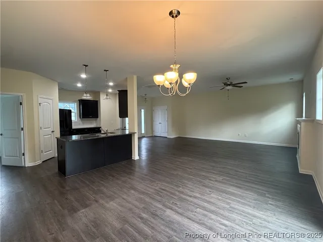 a kitchen with stainless steel appliances granite countertop wooden cabinets a stove a sink and a wooden floor