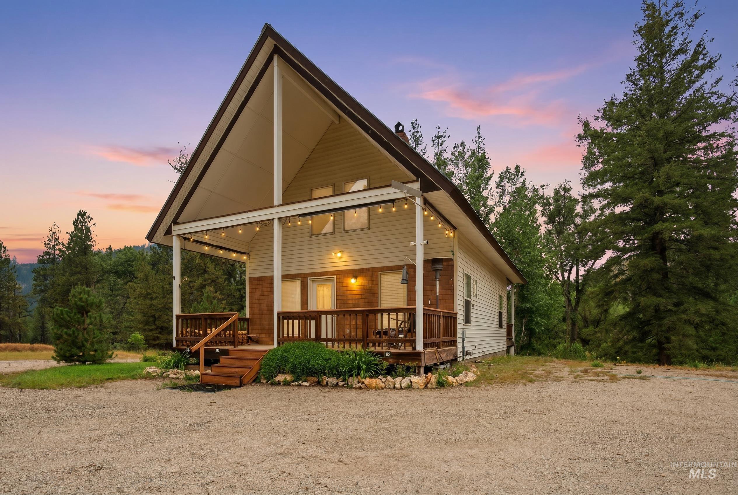 3980 North Pine-Featherville Road Mountain Home, ID 83647 - Photo 2 of 35 A-frame residence with a covered porch, wood plank siding, and a gravel driveway