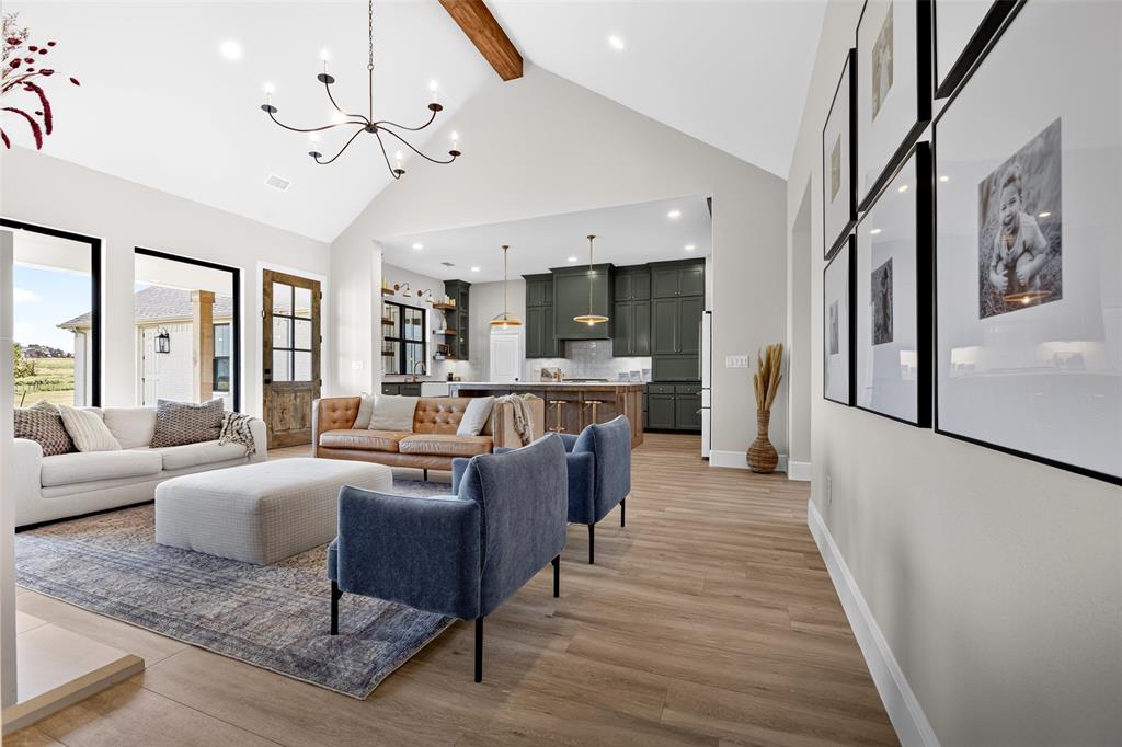 10978 Gregory Road Sanger, TX 76266 - Photo 11 of 40 Vaulted ceiling with exposed wood beam, open-concept design, wide-plank wood-finish flooring, recessed lighting, and a modern chandelier