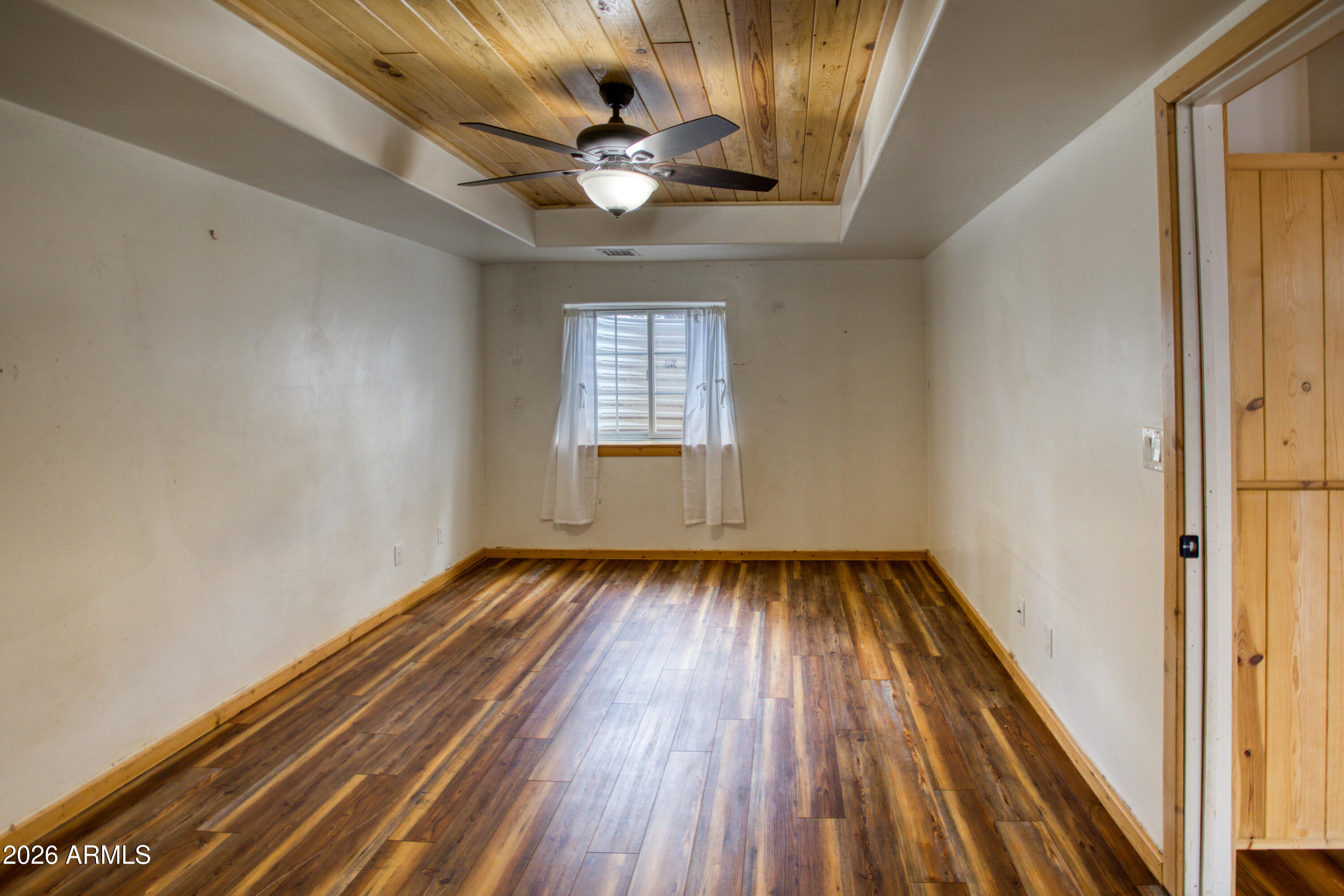 1420 Meadow View Place Show Low, AZ 85901 - Photo 19 of 25 a view of an empty room with wooden floor and a window