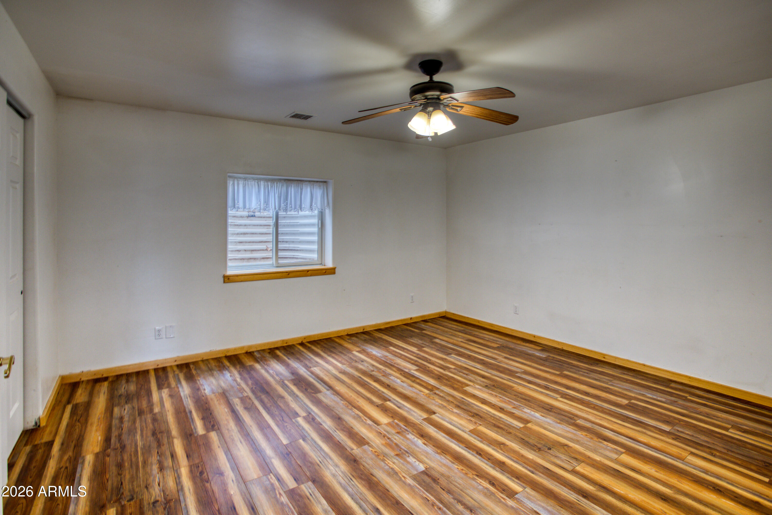1420 Meadow View Place Show Low, AZ 85901 - Photo 21 of 25 a view of an empty room with wooden floor and a window