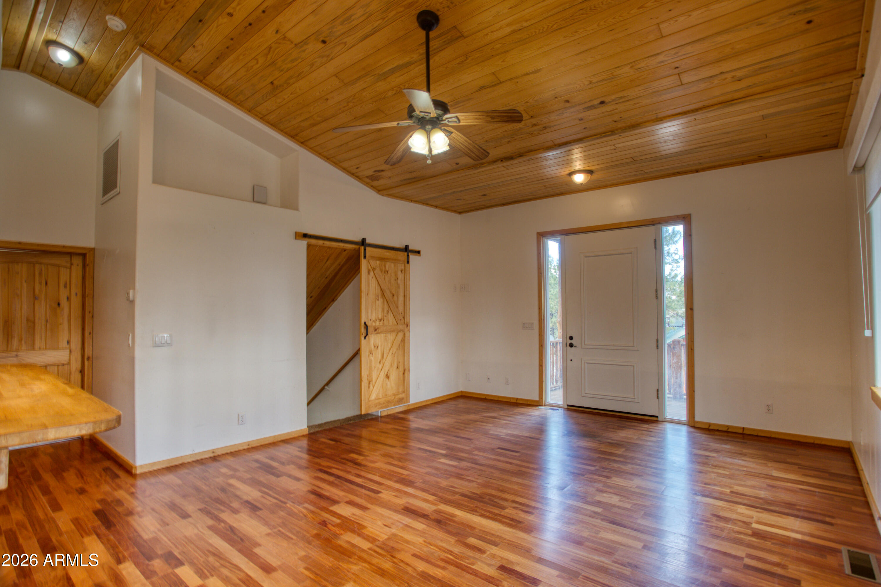 1420 Meadow View Place Show Low, AZ 85901 - Photo 5 of 25 a view of an empty room with wooden floor and a ceiling fan