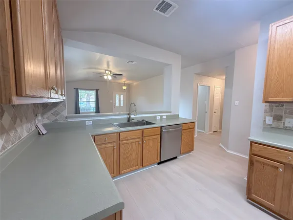 a large kitchen with a refrigerator a sink dishwasher with a stove and cabinets