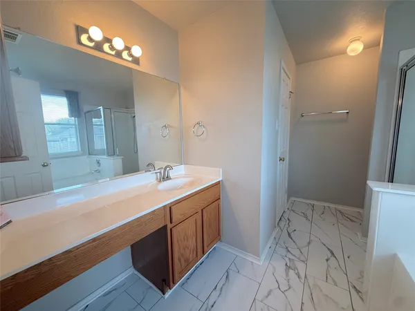 a spacious bathroom with a tub sink and a mirror