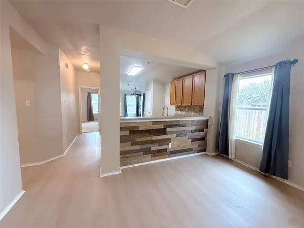 a view of an empty room with a window and fireplace