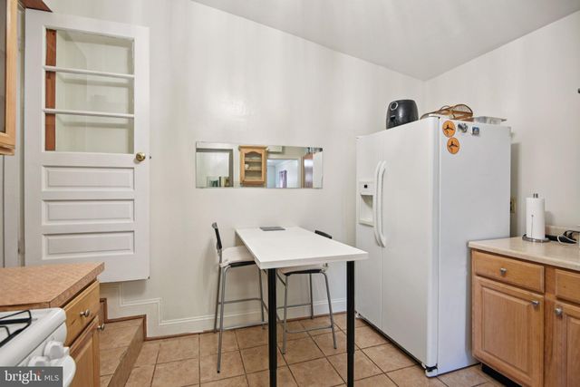 a room with a refrigerator and a stove top oven
