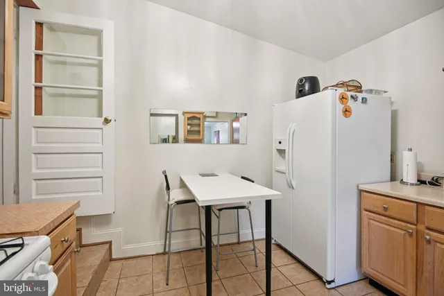 a room with a refrigerator and a stove top oven