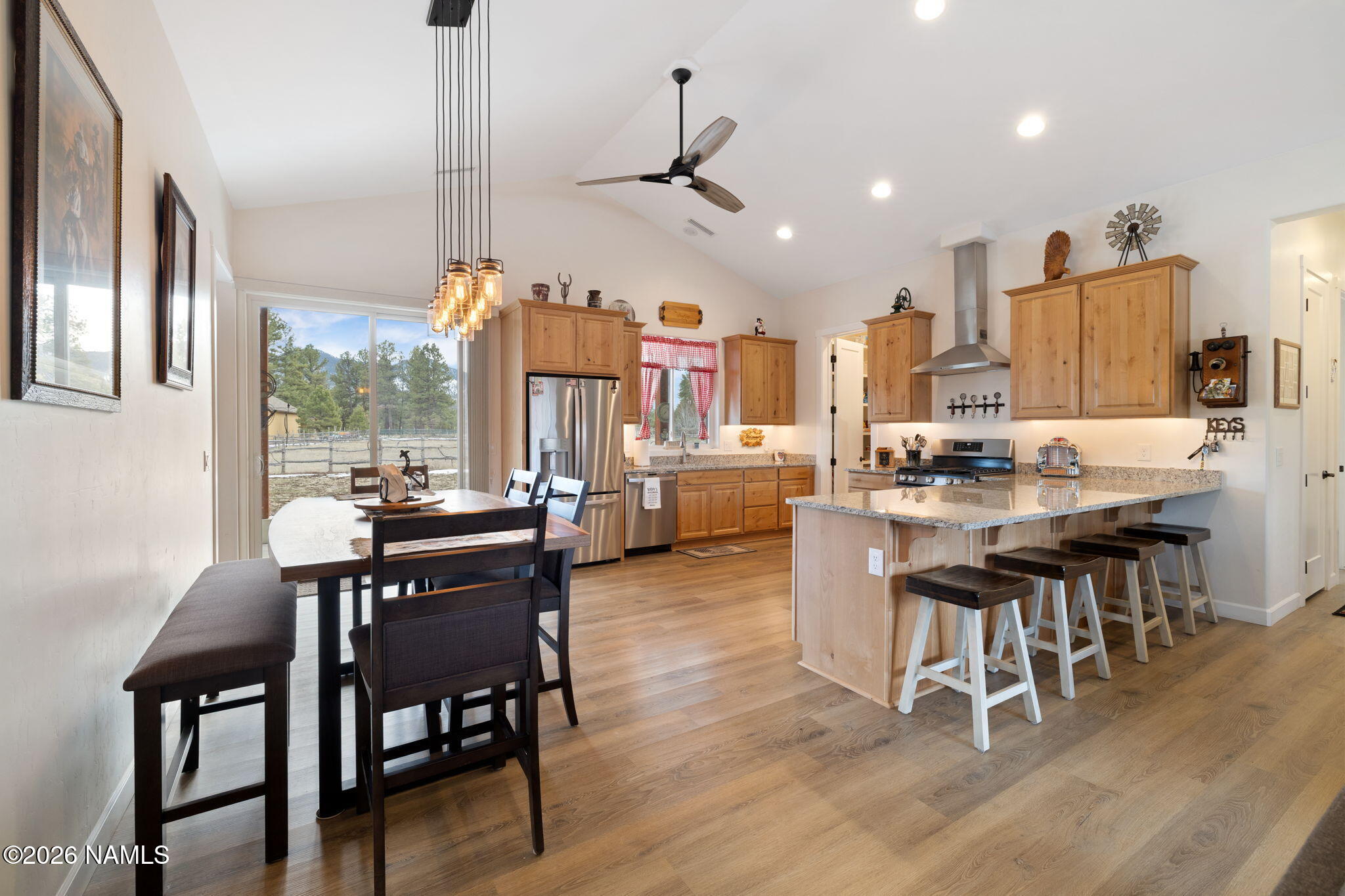 2557 Lazy E Road Williams, AZ 86046 - Photo 11 of 51 a dining room with stainless steel appliances kitchen island granite countertop furniture and wooden floor