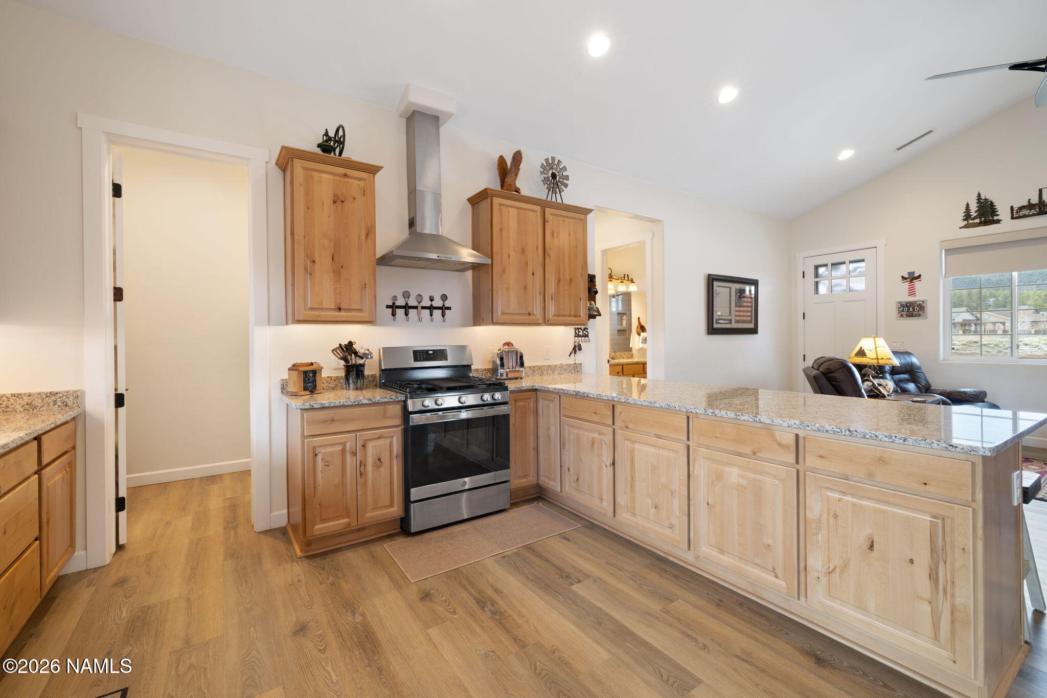 2557 Lazy E Road Williams, AZ 86046 - Photo 9 of 51 a kitchen with stainless steel appliances granite countertop a stove top oven a sink a refrigerator and white cabinets with wooden floor