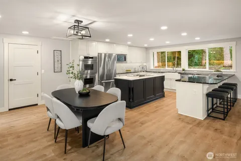a kitchen with kitchen island granite countertop a sink and refrigerator
