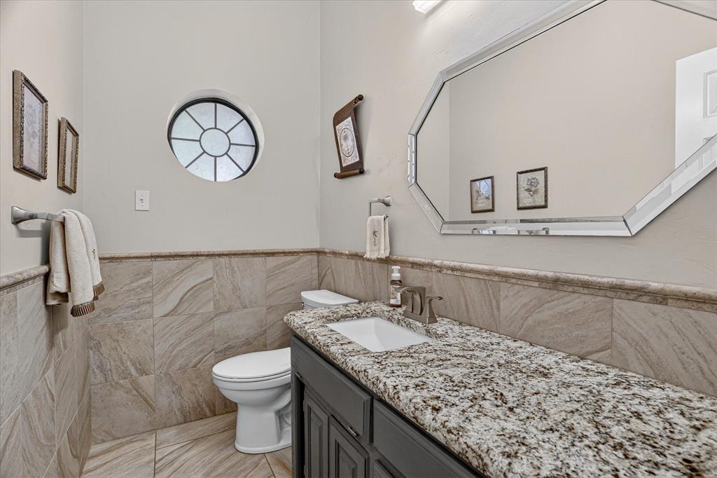 1408 West Cleburne Road Crowley, TX 76036 - Photo 13 of 40 a bathroom with a granite countertop toilet sink and mirror