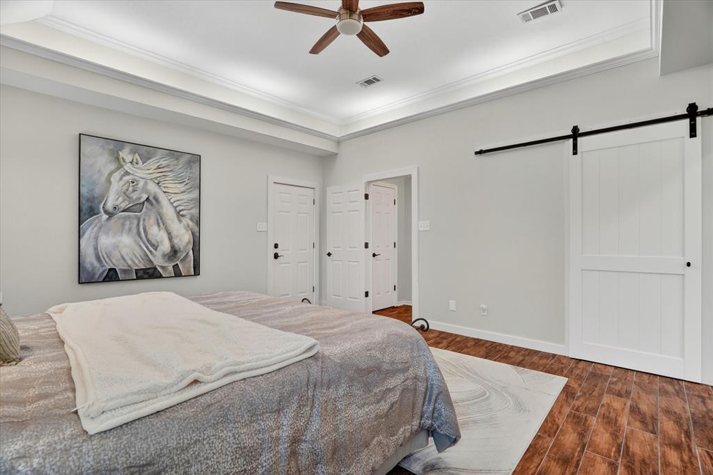 1408 West Cleburne Road Crowley, TX 76036 - Photo 19 of 40 a bedroom with a bed and a painting on the wall