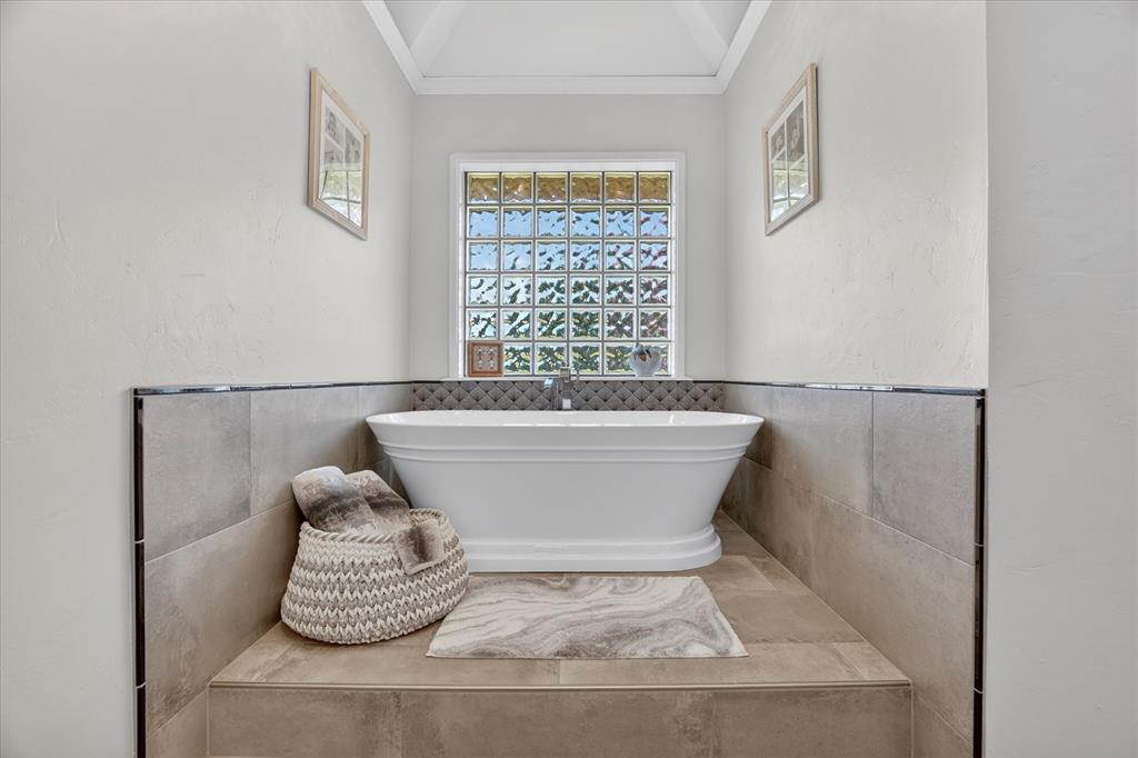 1408 West Cleburne Road Crowley, TX 76036 - Photo 22 of 40 a white bath tub sitting in a bathroom next to a window
