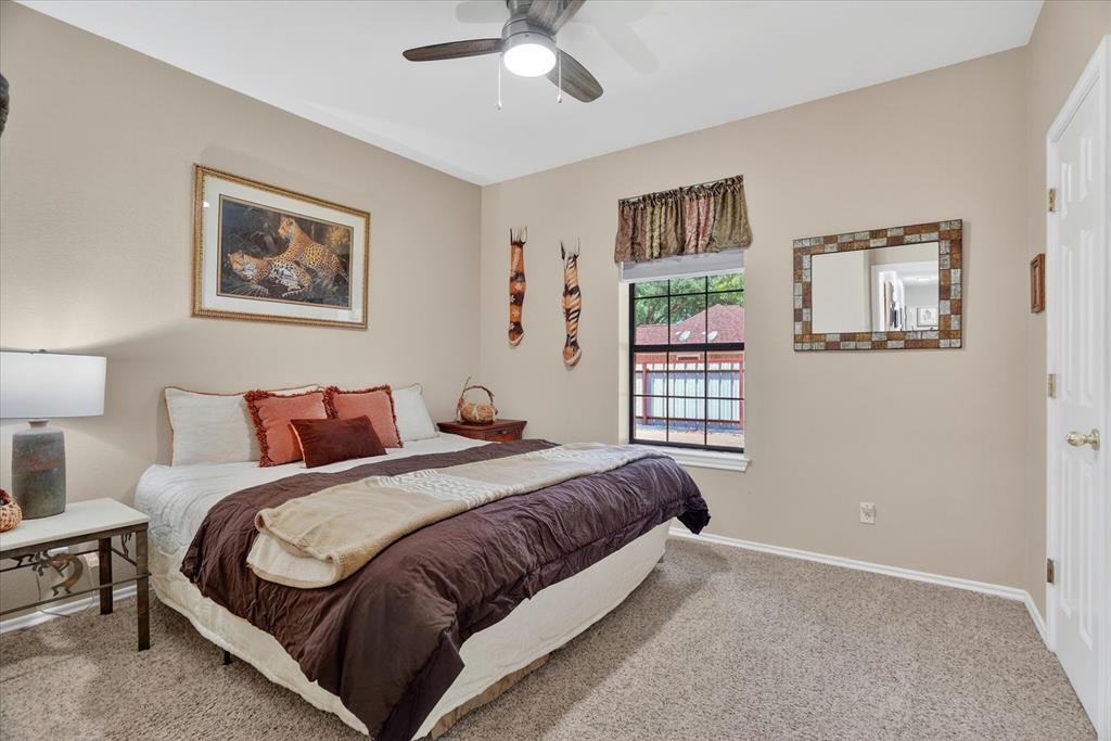 1408 West Cleburne Road Crowley, TX 76036 - Photo 27 of 40 a spacious bedroom with a bed and a painting on the wall