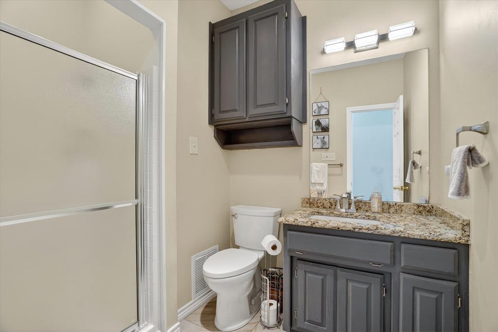 1408 West Cleburne Road Crowley, TX 76036 - Photo 28 of 40 a bathroom with a granite countertop sink toilet and shower