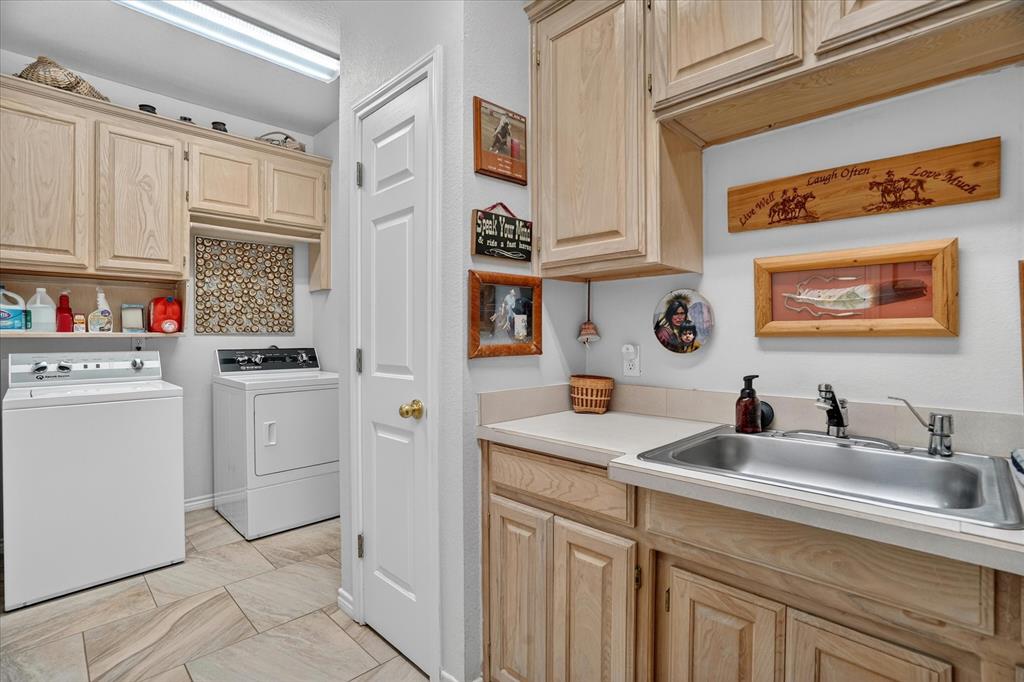 1408 West Cleburne Road Crowley, TX 76036 - Photo 29 of 40 a utility room with stainless steel appliances a sink and cabinets