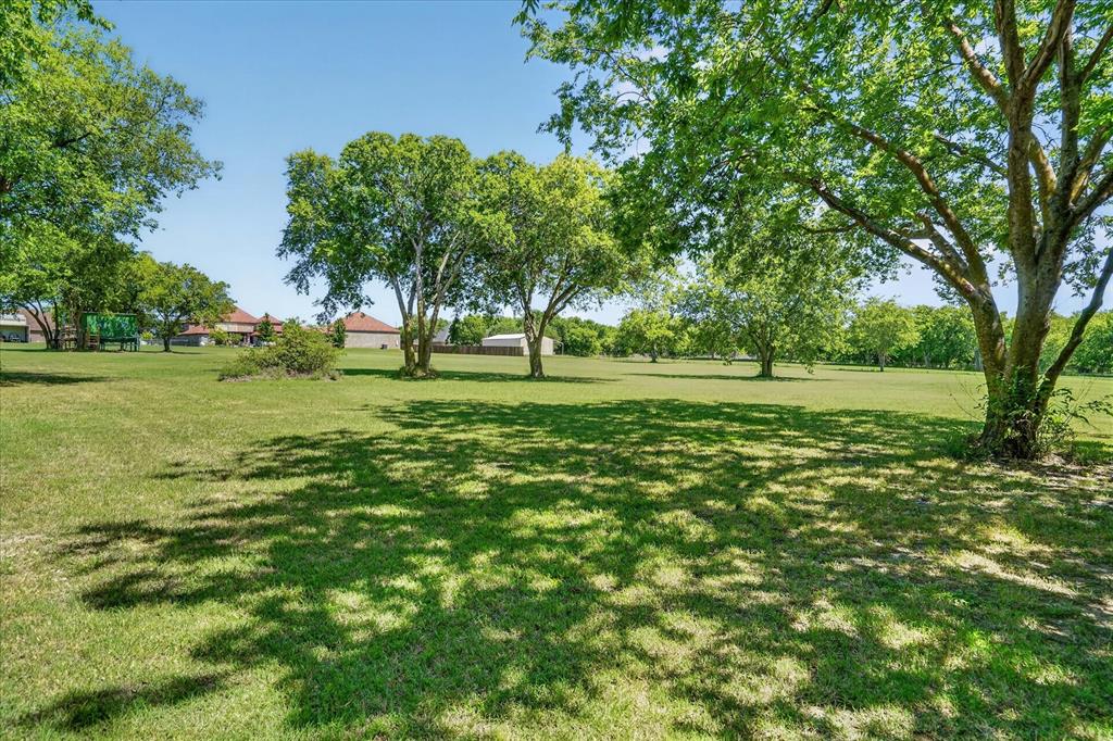 1408 West Cleburne Road Crowley, TX 76036 - Photo 39 of 40 a big yard with lots of green space and trees