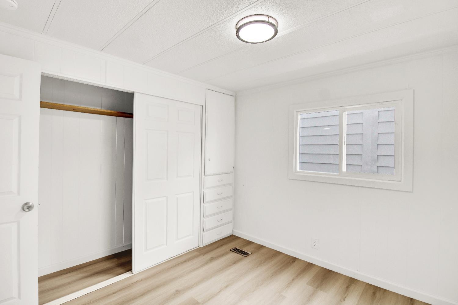 4143 Yosemite, Unit C21 Modesto, CA 95357 - Photo 24 of 25 an empty room with wooden floor and windows