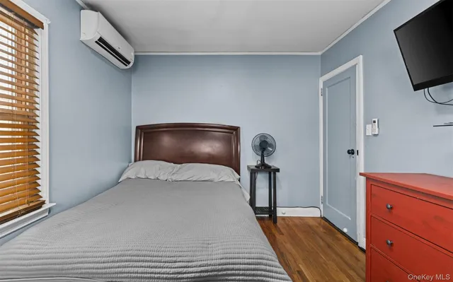 a bedroom with a bed and a flat tv screen on dresser