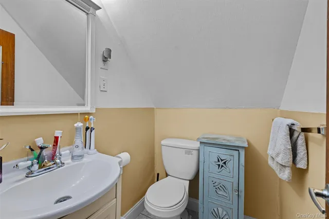 a bathroom with a sink vanity mirror and toilet
