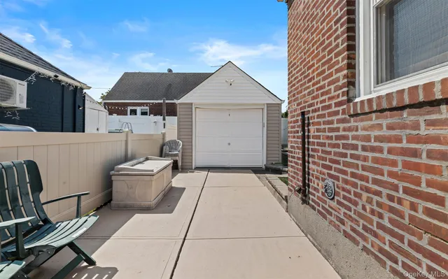 a backyard of a house with wooden fence and a bench