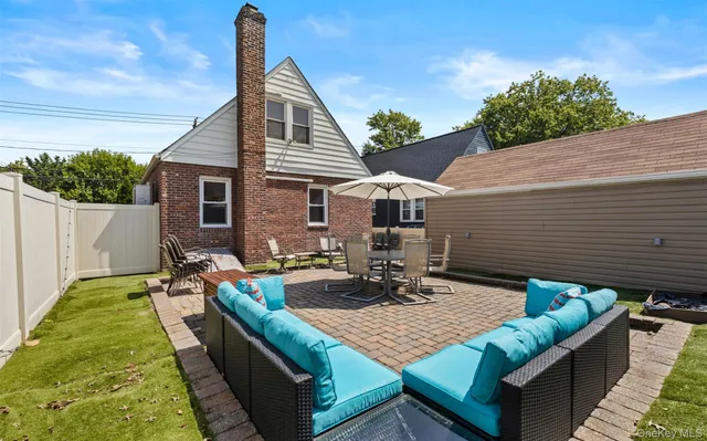 a view of house with backyard and sitting area