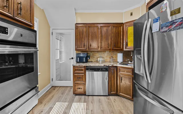 a kitchen with stainless steel appliances a refrigerator a stove a sink and cabinets