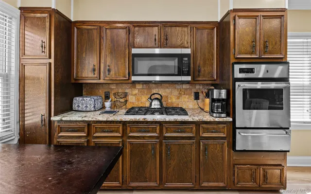 a kitchen with stainless steel appliances granite countertop a refrigerator and a stove top oven