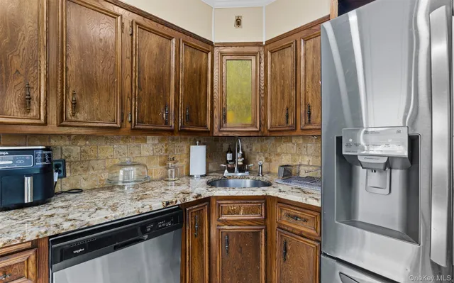 a kitchen with stainless steel appliances granite countertop a refrigerator and a sink