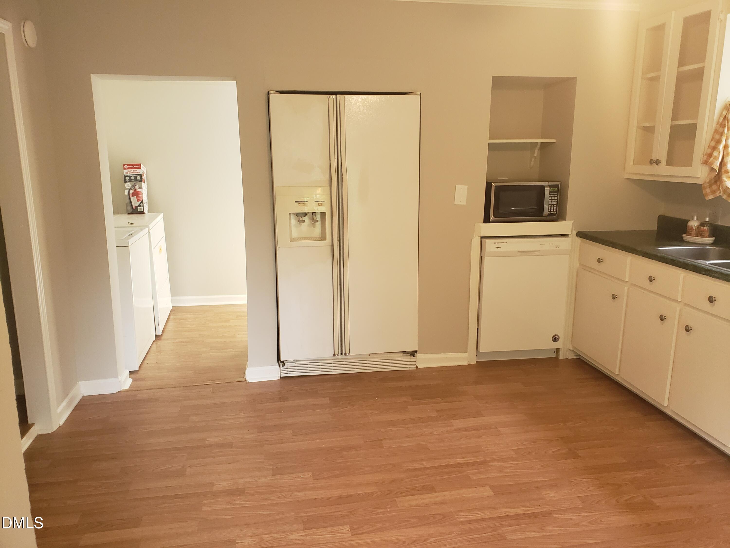 306 South Moore Street Clayton, NC 27520 - Photo 11 of 31 a view of a refrigerator in kitchen and wooden floor