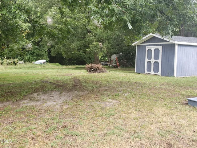 a front view of a house with a yard and trees