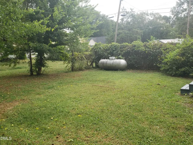 a backyard of a house with table and chairs