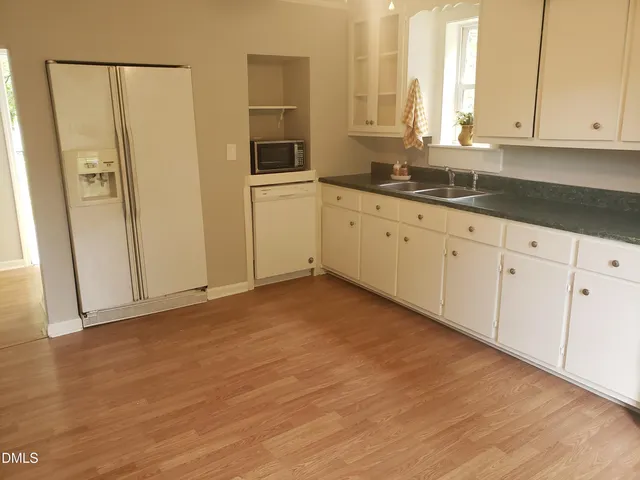 a kitchen with stainless steel appliances granite countertop white cabinets and window
